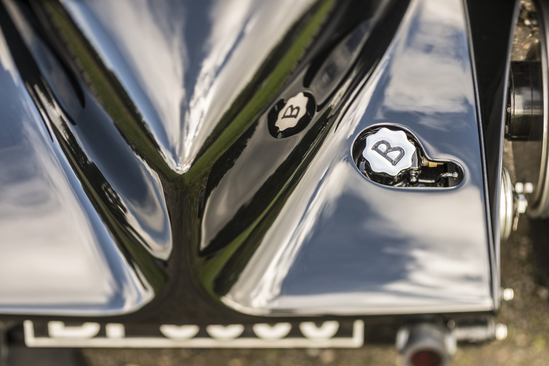 Detail of the twin B-monogrammed fuel caps set into the polished rear deck
